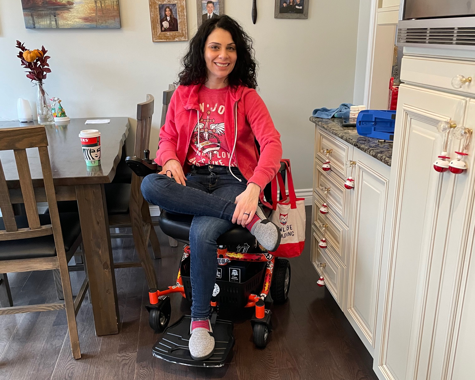 a model dressed in red ugly  Crist mass  sweatshirt sitting on a power scooter